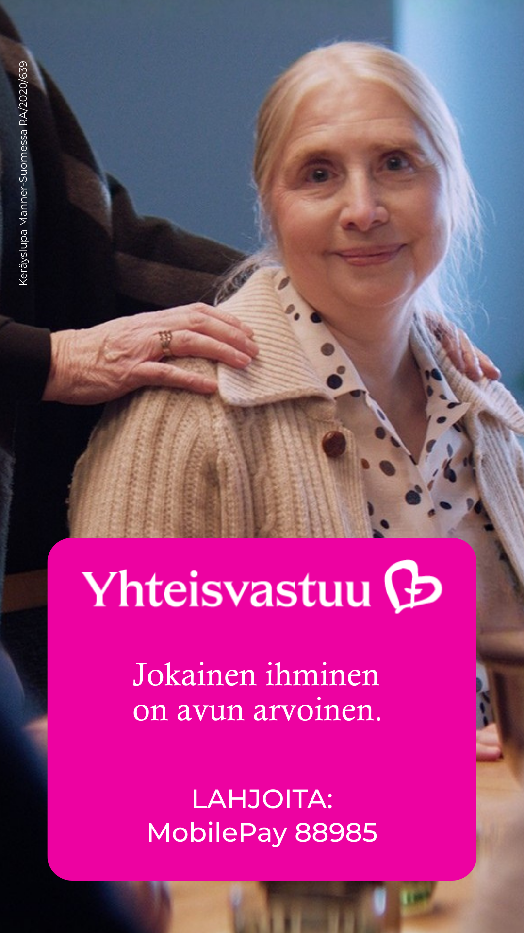 Vanhus istuu ja katsoo kameraan, toinen vanhus seisoo takana ja pitää käsiä kevyesti vanhuksen olkapäällä