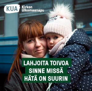 Pieni lapsi äidin sylissä talvivaatteet päällä, katsovat kameraan. Taustalla junanvaunu